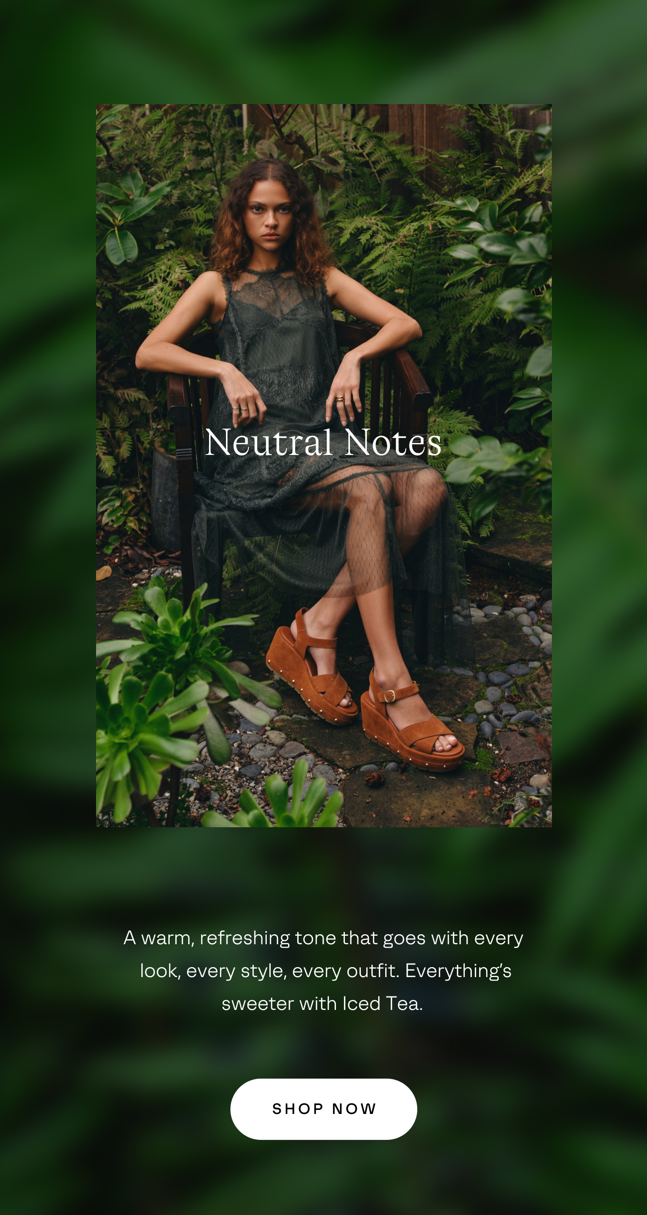 Woman wearing sandals in iced tea color sitting on chair surrounded by green foliage