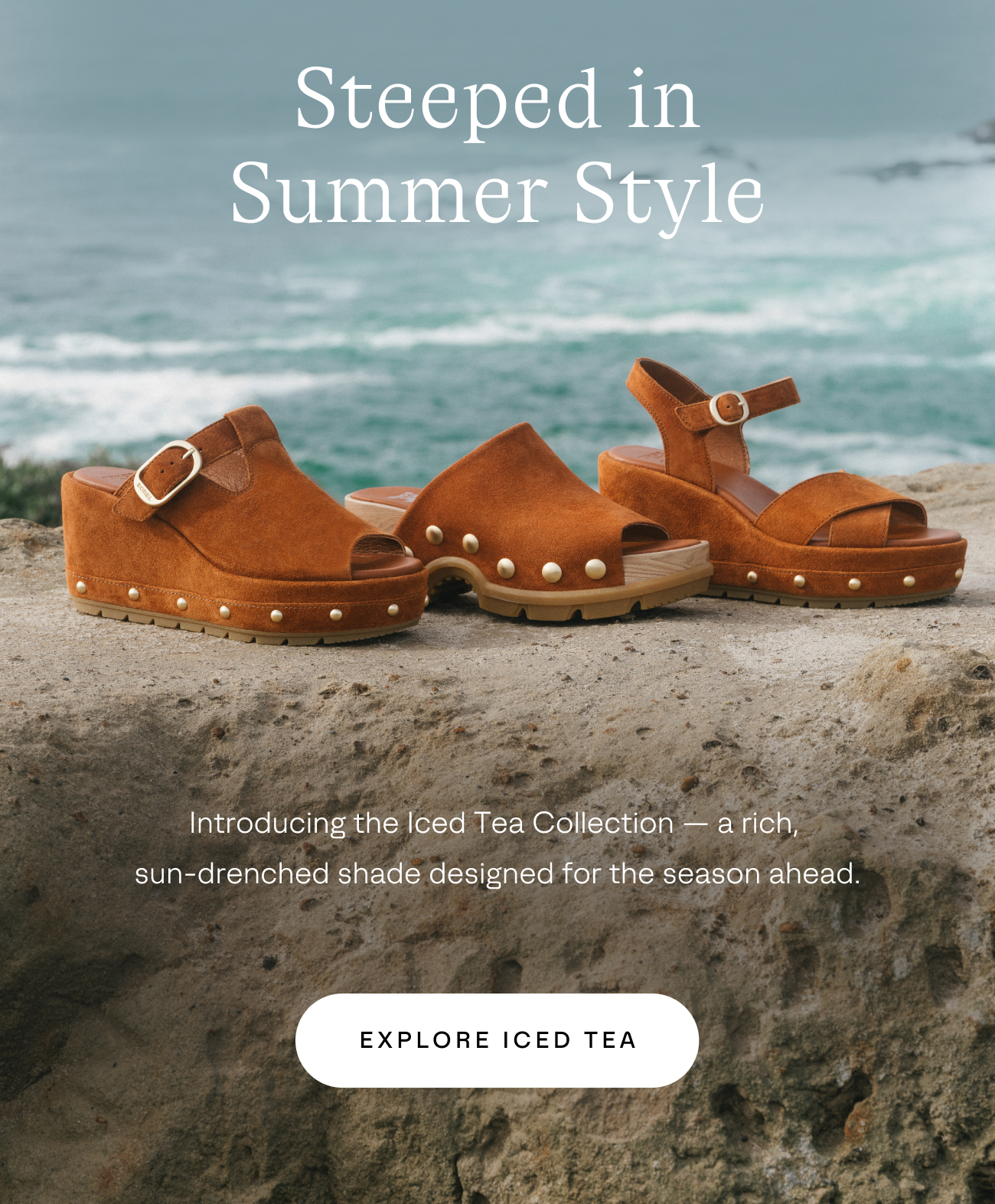 Sandals in iced tea color sitting on rock ledge with waves behind it